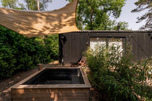 a wooden building with a sink in the yard at Luxe Hottub Japandi Tiny house in het Bos in Nunspeet