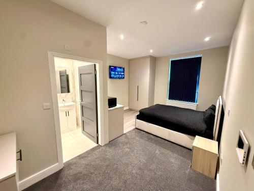 a small bedroom with a bed and a bathroom at Aire House, Keighley in Keighley