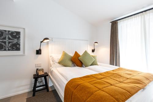 a bedroom with a large bed with a yellow blanket at Seta Hotel in Bellagio