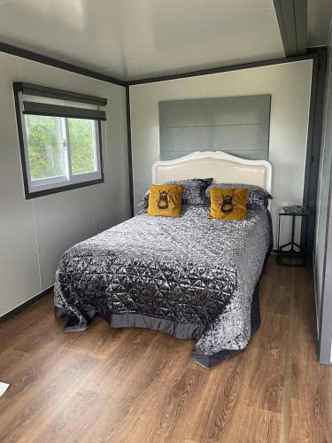 a bedroom with a bed with yellow pillows on it at Stunning birch tree Lodge in Otley