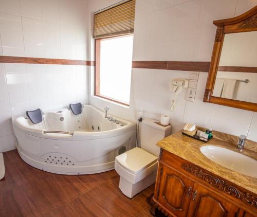 a bathroom with a tub and a toilet and a sink at Kings Ridge Kandy in Kandy