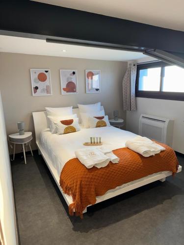 a bedroom with a large bed with towels on it at Résidence du Champ Lamet in Pont-du-Château