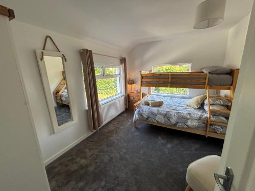 a bedroom with a bunk bed and a mirror at Craigport Cottage in Portrush