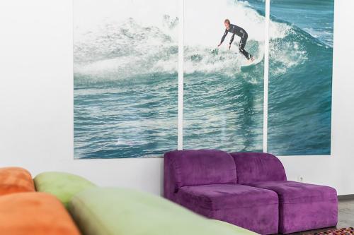 a man riding a wave on a surfboard in the ocean at Hi Espinho - Pousada de Juventude in Espinho