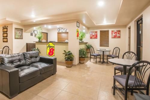 a living room with a couch and tables and chairs at Super 8 by Wyndham Colby in Colby