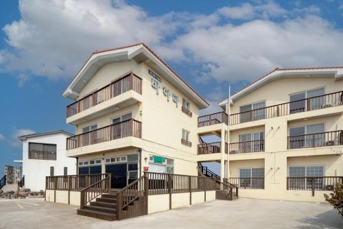 a large white building with wooden balconies at Jeju Bahama Pension in Jeju