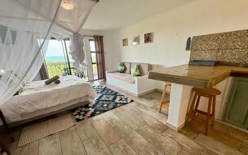 a bedroom with a bed and a desk with a window at Go Wild Beach Resort in Quebanhane