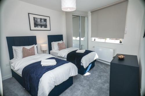 a hotel room with two beds and a window at Little Haven Thames view Free Parking Closer to Heathrow in Staines