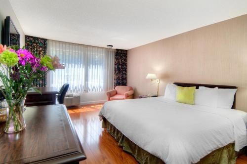 a hotel room with a bed and a table with flowers at County Inn in Mountain View