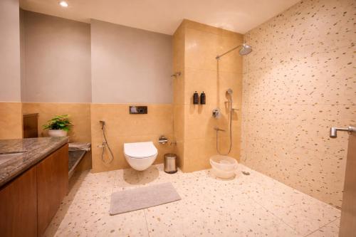 a bathroom with a toilet and a shower and a sink at Pride Premier Darjeeling in Darjeeling