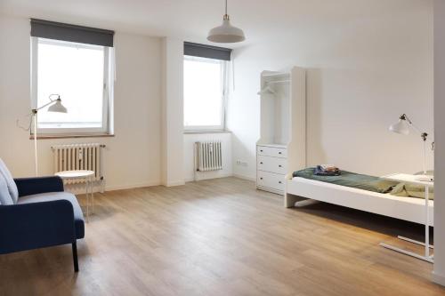 a white room with a bed and two windows at Zentrale Monteurwohnung in Oldenburg i H in Oldenburg in Holstein