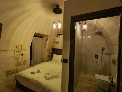 a bedroom with a bed and a walk in shower at Mara Loya Konağı in Mardin