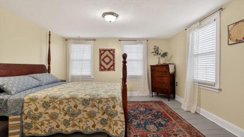 a bedroom with a bed and a dresser and windows at Victory View in Gettysburg