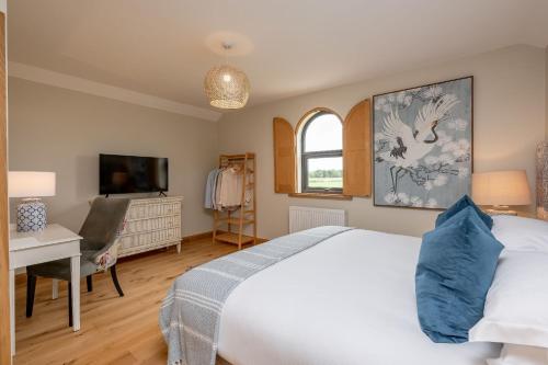 a bedroom with a bed and a desk and a tv at Ellesmere Barn in Bedale