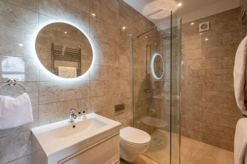 a bathroom with a sink and a toilet and a mirror at Ellesmere Barn in Bedale