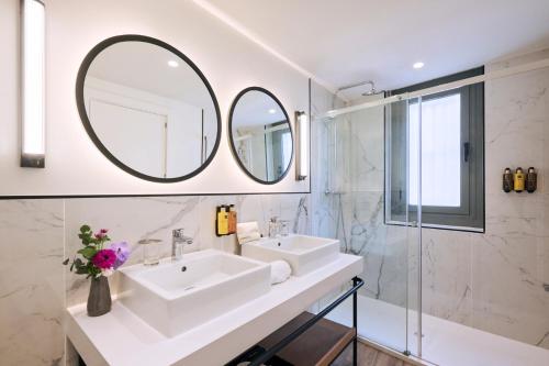 a bathroom with two sinks and a mirror at H10 Raco del Pi Boutique hotel in Barcelona