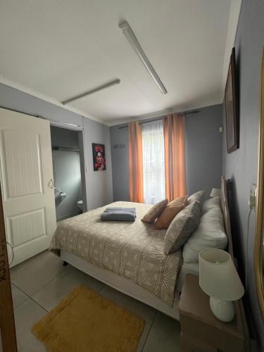 a bedroom with a bed with pillows and a window at Cottage 49 in Parys