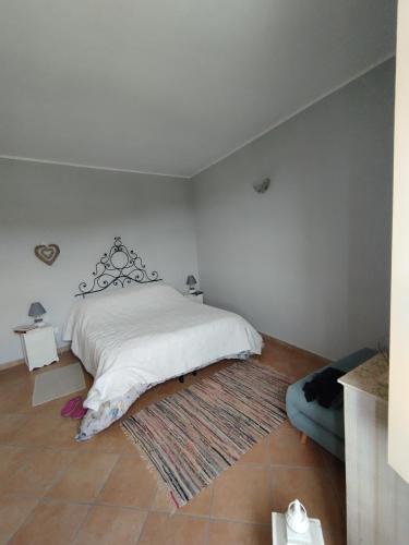 a bedroom with a white bed and a rug at Casa Adamo 77 in Badolato