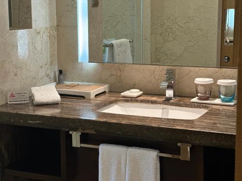 a bathroom counter with a sink and a mirror at Hotel Nikko Xiamen in Xiamen