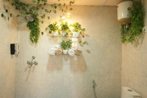 a bathroom with a bunch of plants on the wall at 1BHK Suite with Balcony and Pool View in Noida