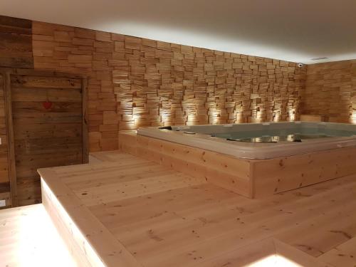 a jacuzzi tub in a room with a brick wall at Aqua Apartments Spa Housemuhlbach in Sappada