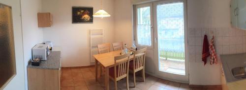 cocina con mesa, sillas y ventana en Ferienwohnung Grimmer, en Weil am Rhein