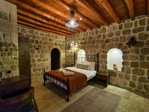 a bedroom with a bed in a room with stone walls at Mara Loya Konağı in Mardin