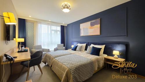 a bedroom with a large bed and a desk and a desk at Hotel Siesta in Užice