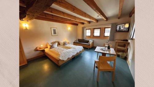 a bedroom with a bed and a couch and a table at Deutsches Haus Hotel Restaurant Gastwirtschaft Biergarten am Radweg Bermuthshain in Bermuthshain