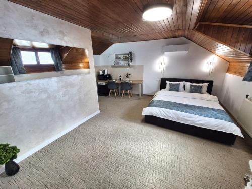 a bedroom with a large bed and a table at Central Stay Suites Targu Mures in Târgu-Mureş