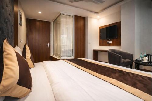 a hotel room with a large bed and a television at Mukul inn in Gurgaon