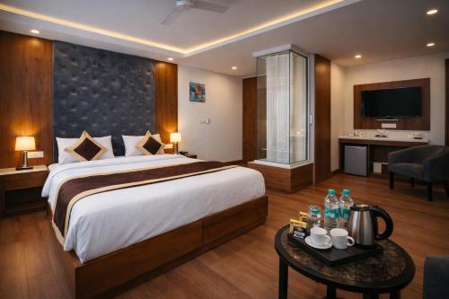 a hotel room with a large bed and a table at Mukul inn in Gurgaon
