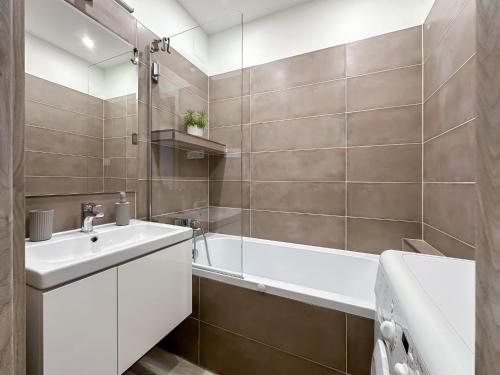 a bathroom with a white sink and a bath tub at Apartmán/byt Liptovský Mikuláš in Liptovský Mikuláš