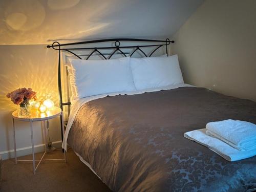 a bedroom with a bed and a table with a lamp at The Flat in Tintinhull