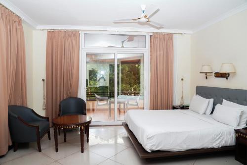 a bedroom with a bed and a table and a chair at Ctrl Alt Heal Sparsh Integrated Wellness Center in Hyderabad