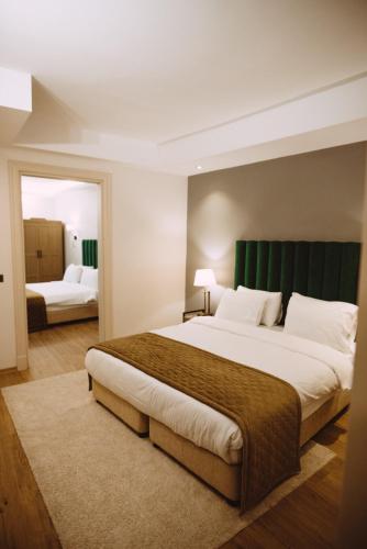 a bedroom with a large bed with a green headboard at Mest Hotel Istanbul Sirkeci in Istanbul