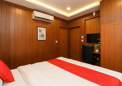 a bedroom with a bed and a desk and a television at Hotel Meerut International in Meerut