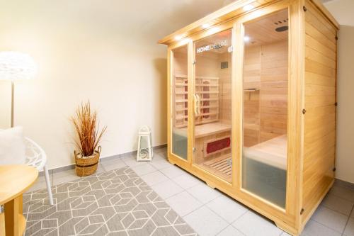 a wooden cabinet with glass doors in a room at Haus-Eriel-EG-rechts in Brösum