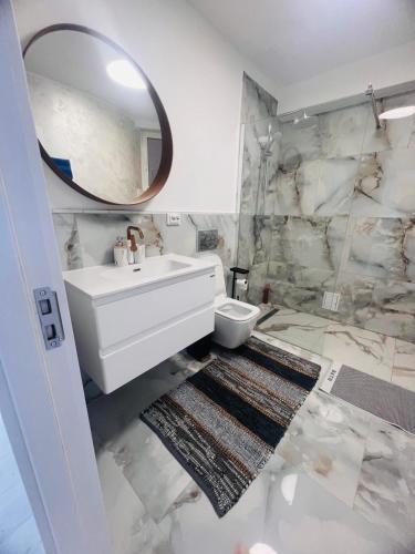 a white bathroom with a sink and a mirror at Apartamente CASA MIRIAM in Lugoj
