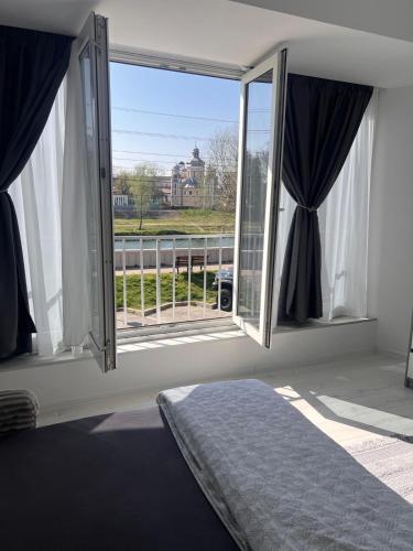 a bedroom with a bed and a large window at Apartamente CASA MIRIAM in Lugoj