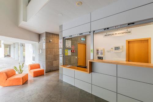 a lobby with an orange chair in a building at Hi Espinho - Pousada de Juventude in Espinho