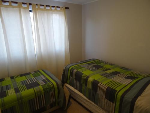 a bedroom with a bed and a window with curtains at TerraBahia Residences in Bahia Inglesa