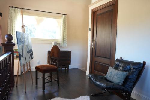a living room with a leather chair and a window at La Torre Retreat in Borredá
