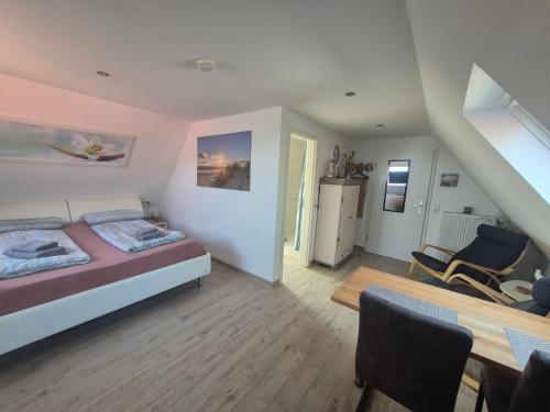 a bedroom with a bed and a dining room at Apartmenthaus Westerkoog in Hedwigenkoog