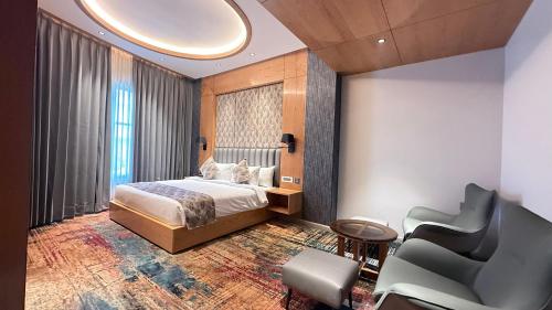 a hotel room with a bed and two chairs at Ananta Express, Katra in Katra