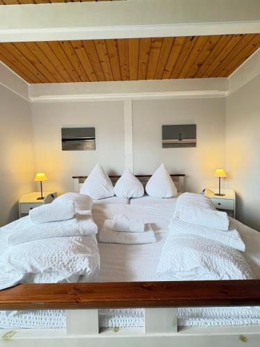 two beds in a bedroom with two lamps on either side at Ferienwohnung Heimat auf Zeit Pellworm in Pellworm