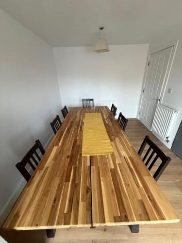 a large wooden table in a room with chairs at 4-Bed Contractor Friendly House Long Stays Welcome in Luton