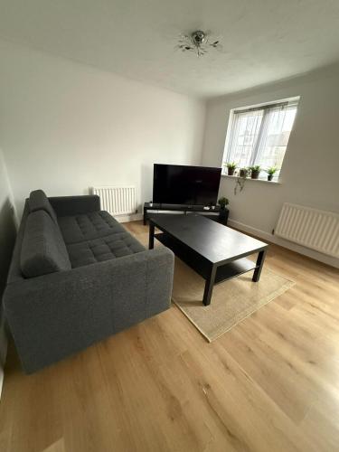 a living room with a couch and a coffee table at 4-Bed Contractor Friendly House Long Stays Welcome in Luton