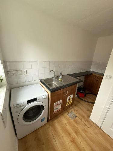 a kitchen with a washing machine and a sink at 4-Bed Contractor Friendly House Long Stays Welcome in Luton