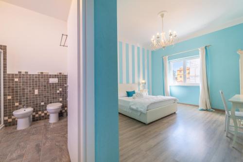 a bedroom with a bed and a bathroom with a toilet at Les Suites Magnolia in Olbia